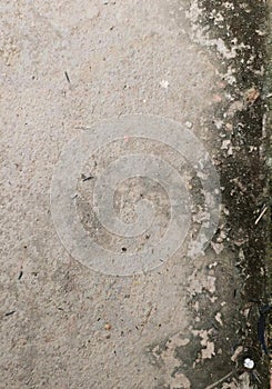 a photography of a dirty sidewalk with a bike leaning against it, padlocked bicycle leaning against a wall on a dirty street