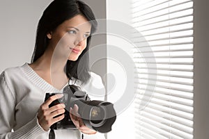 Photography is her hobby. Portrait of beautiful young woman hold