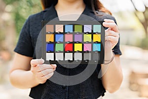 Photography model holding color checker board or colors chart for calibrate accurate colors photos or videos