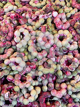 a photography of a pile of red and green onions, brain corals are red and green in color