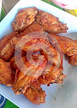 a photography of a plate of chicken wings on a table, paralithodes camtschaticas de pollitos en calzones de chicken photo