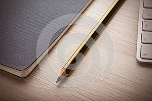 Notepad on wooden desk with pencil photo