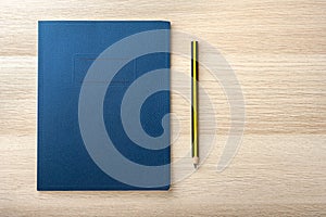 Notepad on wooden desk with pencil photo