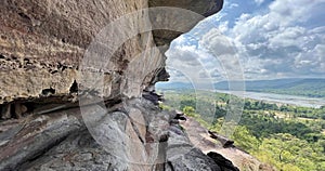 a photography of a rock cliff with a view of a river, drop - off of a rock face with a view of a valley below