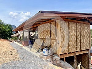 a photography of a small hut with a roof made of bamboo, lumbermill building with a roof made of bamboo and a roof made of bamboo