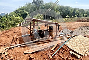 a photography of a small shelter with a roof and a stove, lumbermill with a wooden shelter and a pile of wood