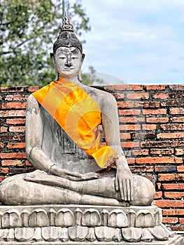 a photography of a statue of a person sitting in a meditation position, there is a statue of a buddha sitting on a stone platform