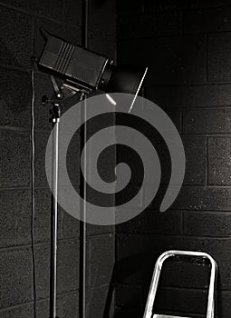 Photography studio light against a black brick wal