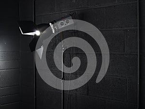 Photography studio light against a black brick wal