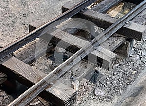 a photography of a train track with a broken rail, lumbermill railroad tracks with a broken rail and a broken rail