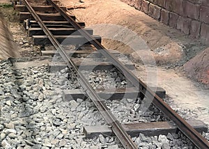 a photography of a train track with a train on it, lumbermill railroad tracks with a train car on the tracks