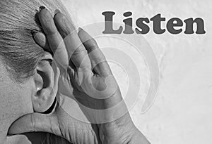 Photography of woman ear making listening gesture with her hand with word Listen