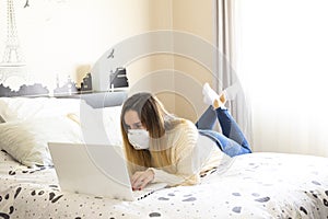 Photography of a woman teleworking in her bed from home. Coronavirus quarantine. Remote working woman