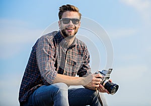 Photojournalist concept. Travel blogger. Reporter taking photo. Guy outdoors blue sky background. Vintage equipment