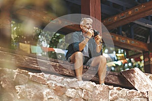 A photojournalist sits near the eastern temple and takes pictures. Retired travel and hobbies