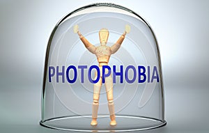 Photophobia can separate a person from the world and lock in an isolation that limits - pictured as a human figure locked inside a photo