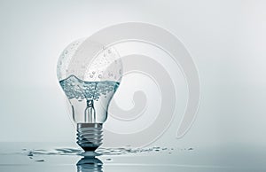 Photorealistic light bulb with water inside standing vertically on the table, puddle around. Ai generated