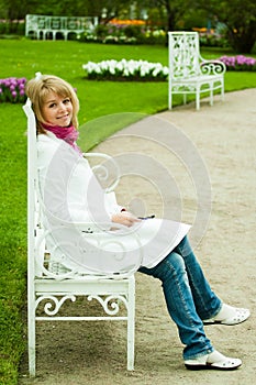 Photos of a blonde girl sitting on a white bench