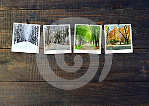 Photos of four seasons attached to dark wooden wall. Seasons on dark background