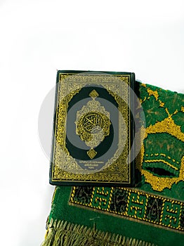 Photos of the Koran and prayer rugs ready for Ramadan.  Arabic on the cover is translated as the Qur'an