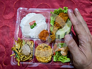 Rice mixed with fried chicken, fried noodles, fried eggs, vegetables and cucumber slices