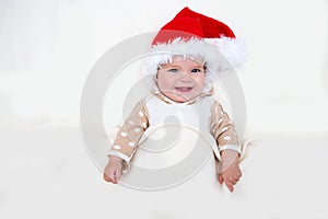 Photos of smiling young baby in a Santa Claus hat
