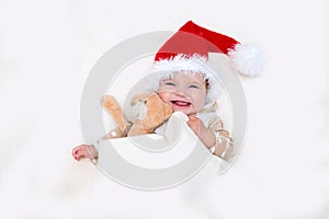 Photos of smiling young baby in a Santa Claus hat