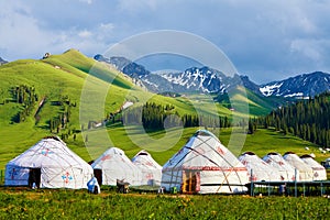The white mongolia yurts in the high mountain meadow photo