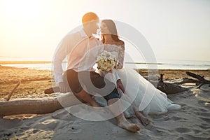 Photoshoot lovers in a wedding dress on the beach near the sea photo