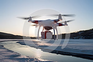 PhotoStock Drone delivers order, medicine, gift, flying over icy river