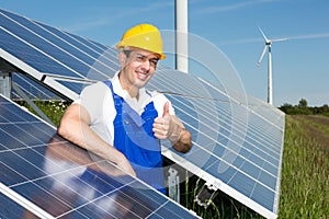 Photovoltaic engineer showing thumbs up at solar panel array