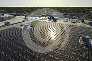 Photovoltaic solar panels mounted on industrial building roof for producing green ecological electricity. Production of