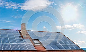 Photovoltaic or solar panels on roof against blue sky