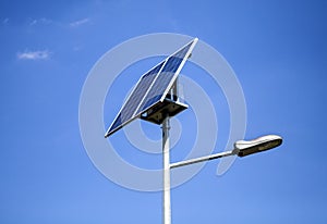 Photovoltaic sun powered street light against blue sky