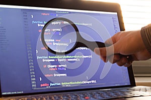 PHP back-end code zoomed through a magnifier. Computer programming source code lookup. Abstract screen of web developer