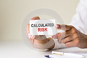 Phrase calculated risk written on a white paper card photo