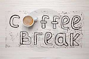 Phrase Coffee Break made with cup of drink and powder on light wooden table, flat lay