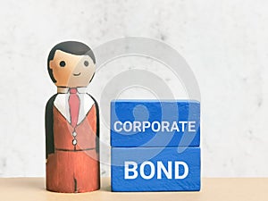 Phrase CORPORATE BOND on blue wooden cubes with businessman doll