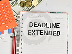 Phrase DEADLINE EXTENDED written on notebook