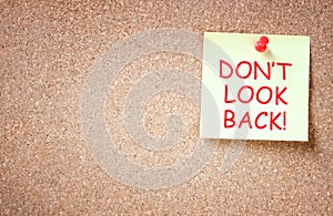 The phrase don't look back written on sticky note. room for text