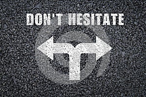 The phrase dont hesitate written on asphalt background photo
