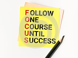 Phrase Follow One Course Until Success written on sticky note with a pencil.