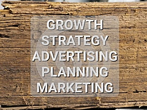 Phrase GROWTH STRATEGY ADVERTISING PLANNING MARKETING written on wooden background.