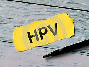 Phrase HPV written on paper strip with a pen.