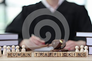 Phrase Human Trafficking with wooden cubes on judge counter