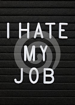 The phrase I Hate My Job in white text on a letter board
