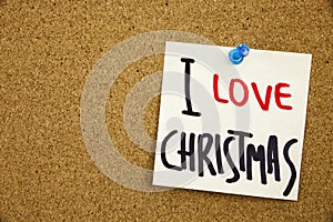 A yellow sticky note writing, caption, inscription Phrase I LOVE CHRISTMAS in black ext on a sticky note pinned to a