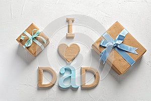 Phrase I LOVE DAD and gift boxes on light background.