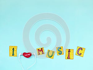 The phrase: `I love music` in cut out letters with earphones, I love music concept.