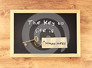 The phrase the key to life is happiness written on blackboard